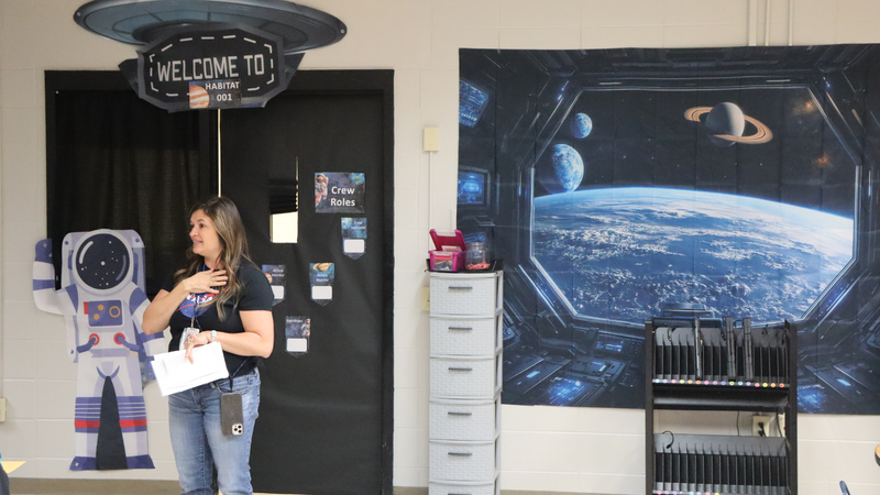 Teacher leads a NASA-themed STEM lesson in a space-inspired classroom.