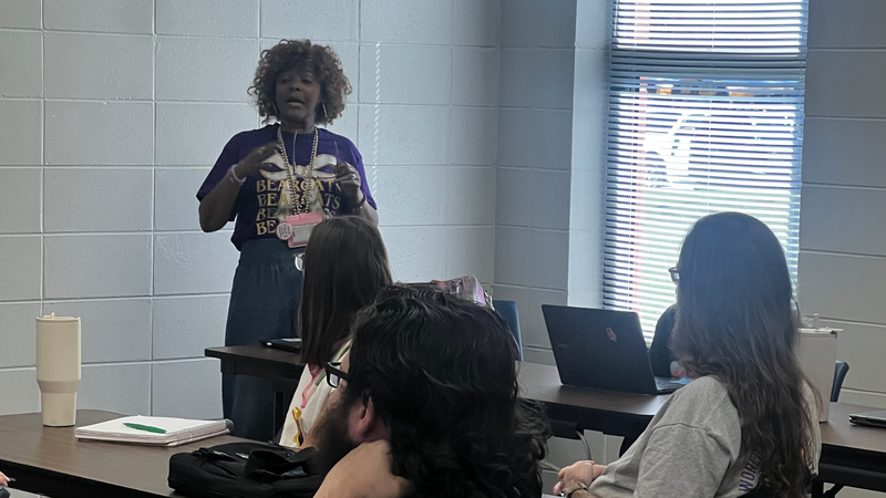 An educator leads a professional development discussion with colleagues during a classroom training session.