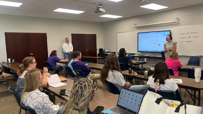 Educators participate in a professional development workshop led by a presenter discussing classroom management strategies.