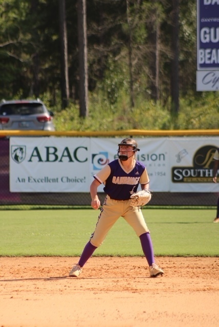 Softball player in outfield waiting to catch a ball. 