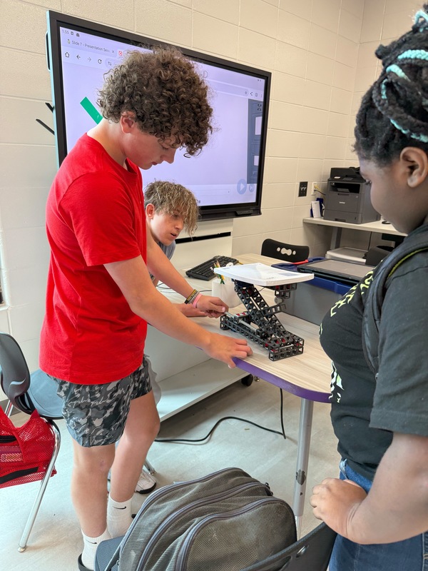 Students testing a simple machine lift they built.