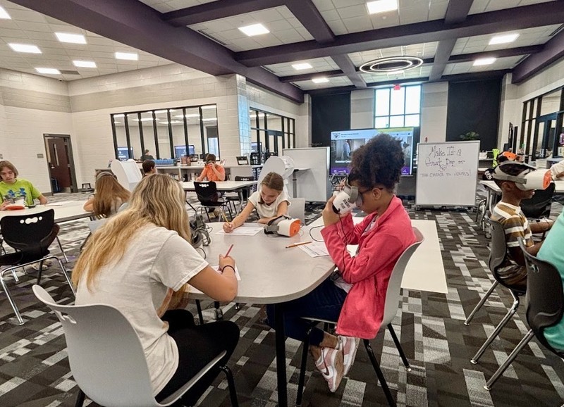3 girls working with VR headsets in the Media Hub
