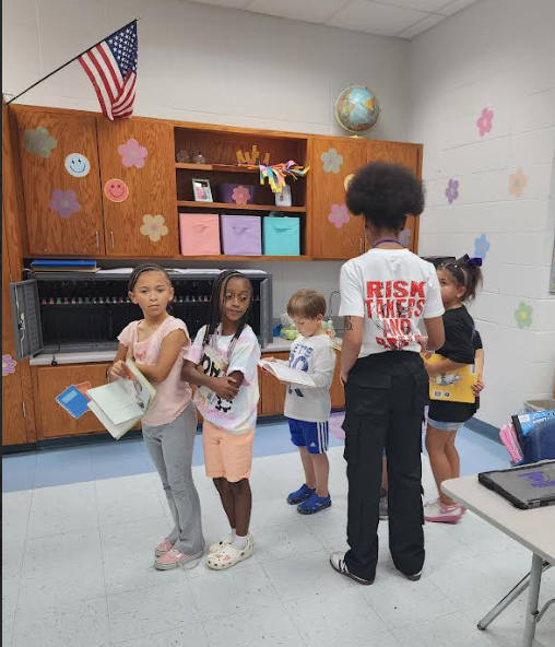 Miracle Jones, Bearcat ECE Intern, is gaining hands-on experience as she helps her mentor teacher prepare students for their library visit.