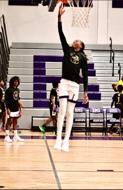 Student in the air shooting the ball