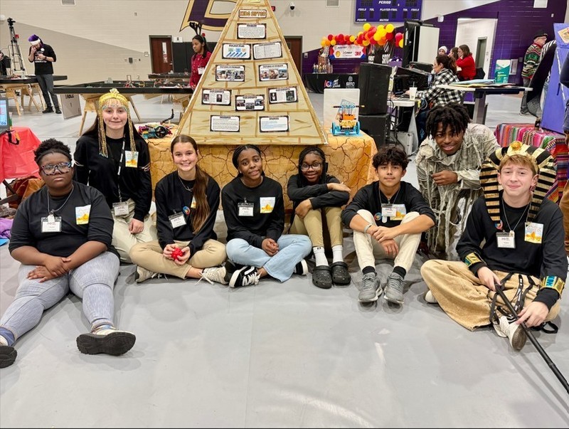 Students sit in front their project.