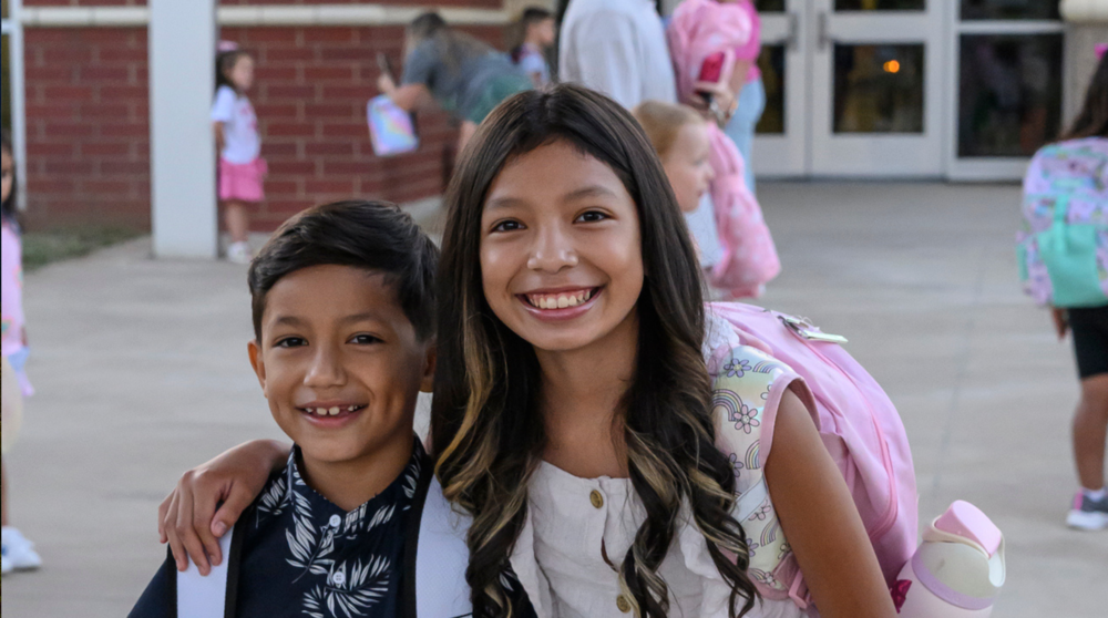 Two siblings pose for a photo on the first day of school at Young Elementary. 