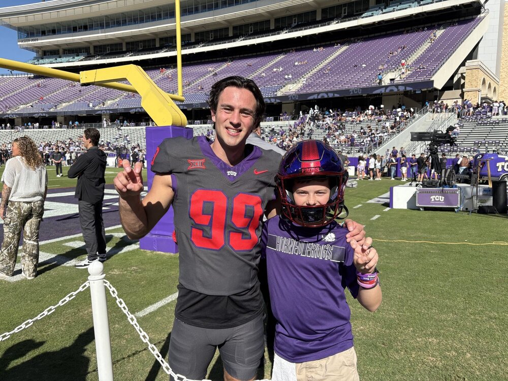 Photo of Heston on the stadium field with a T C U football player