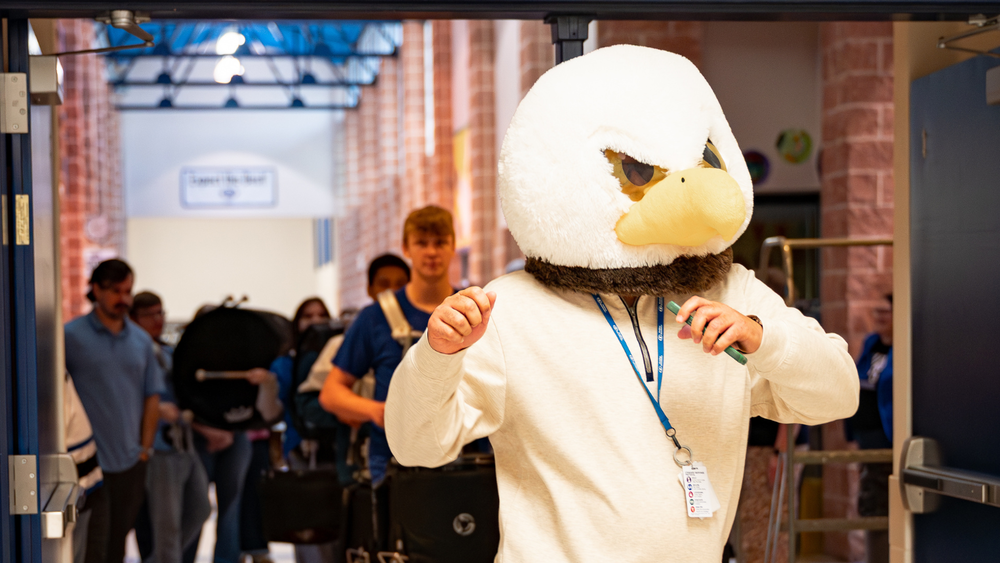 Principal Craig Weston leads the drumline during the grant giveaways 