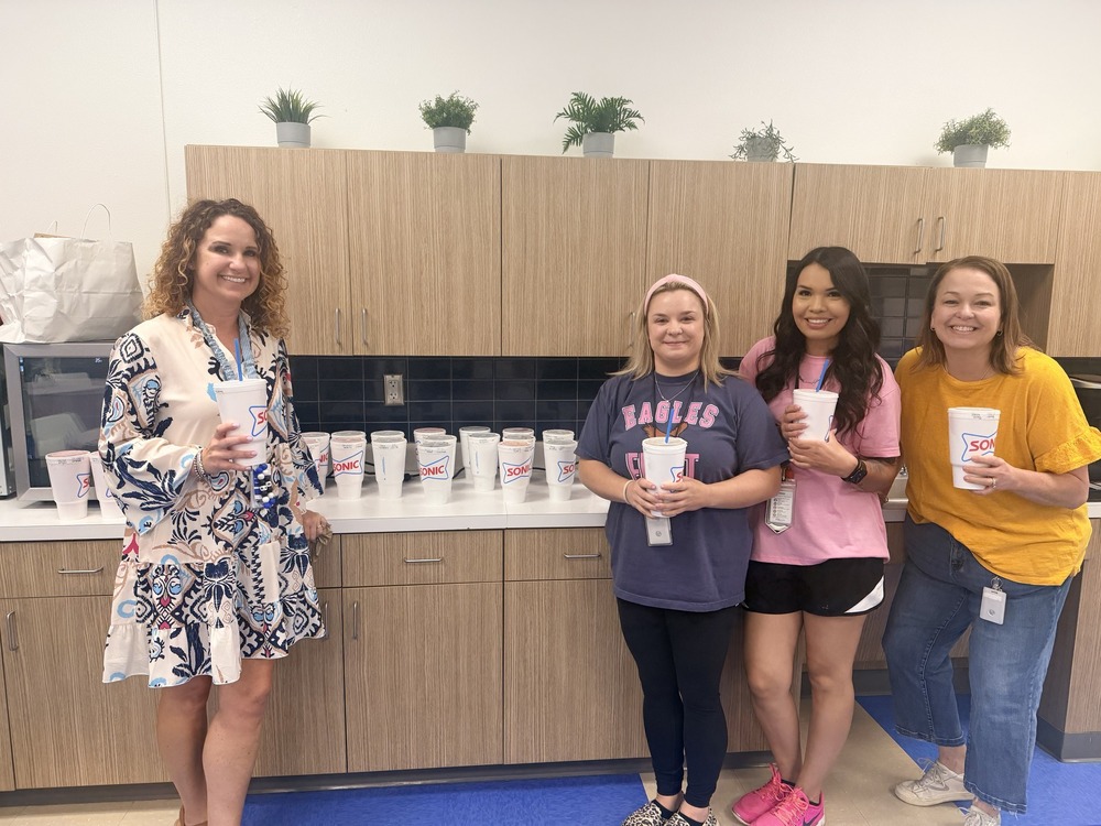 Teachers and staff pose with their staff partner drinks
