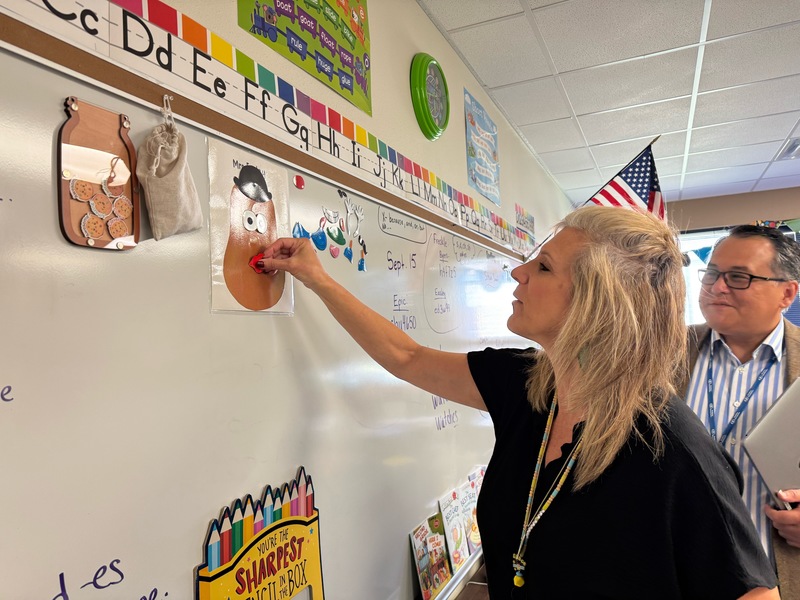 teacher adding lips to a paper patato