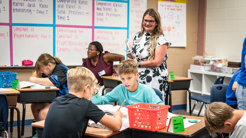 Photo of Aimee Wood looking on with an approving smile during a classroom lesson 