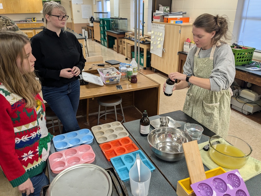 Students watching someone add ingredients to a batch of soap
