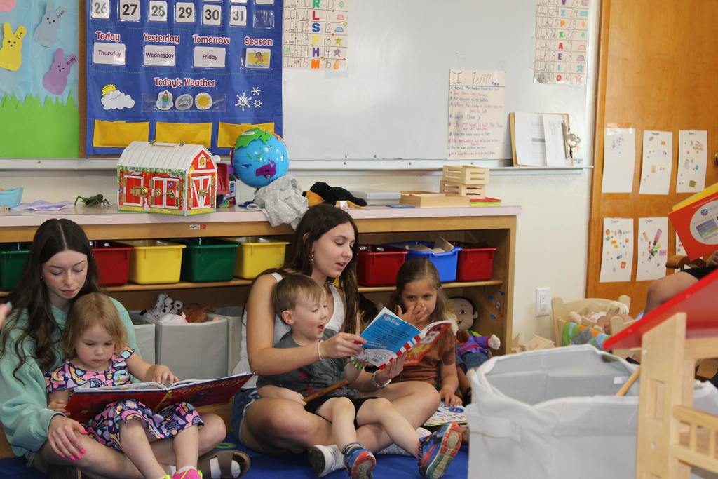 High school and preschool students reading books