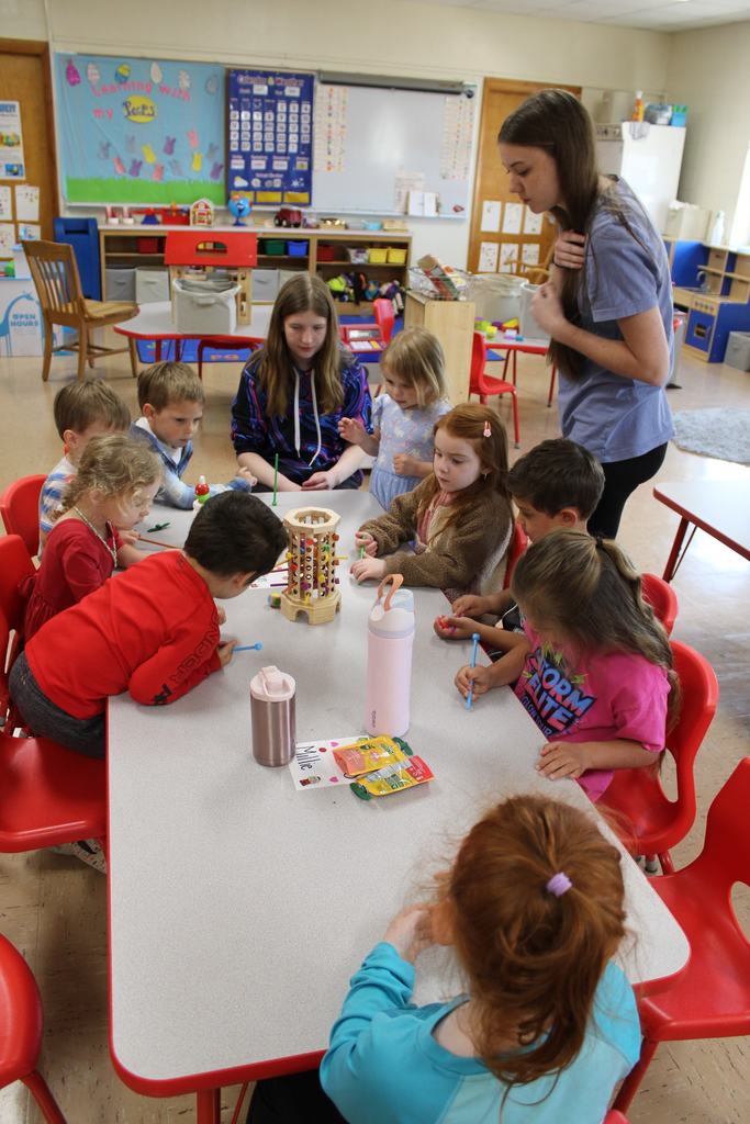 High school and preschool students playing a game in class