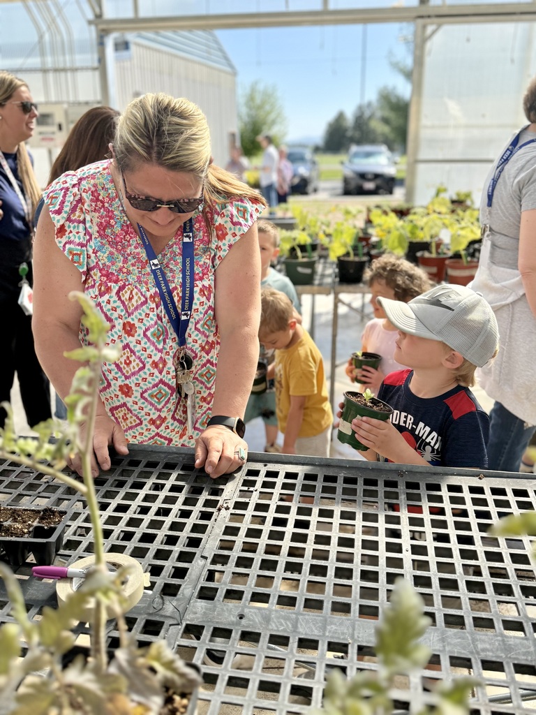 FFA students working in the greenhouse and showing their work to elementary students 