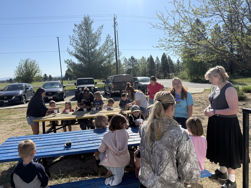 FFA students working in the greenhouse and showing their work to elementary students 