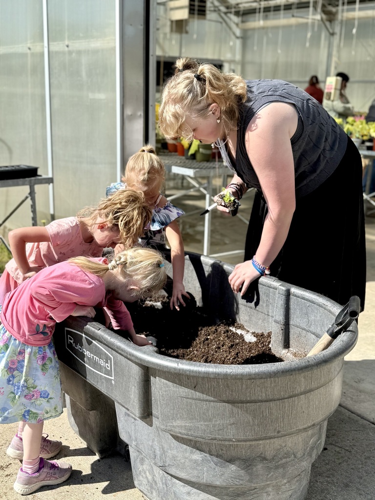 FFA students working in the greenhouse and showing their work to elementary students 