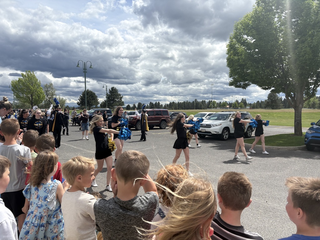 Elementary school students cheering on high school band