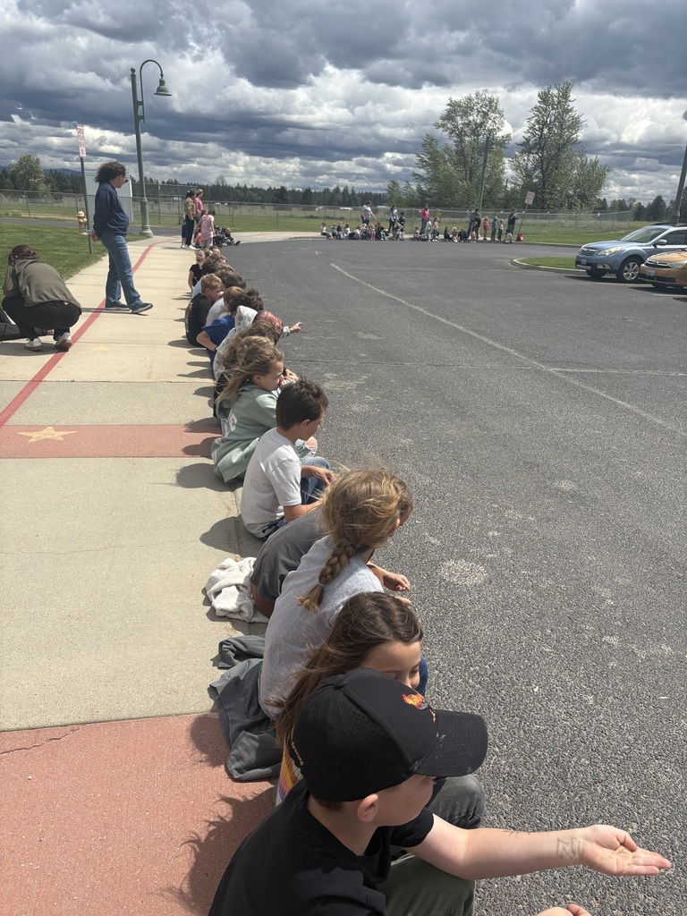 Elementary school students cheering on high school band