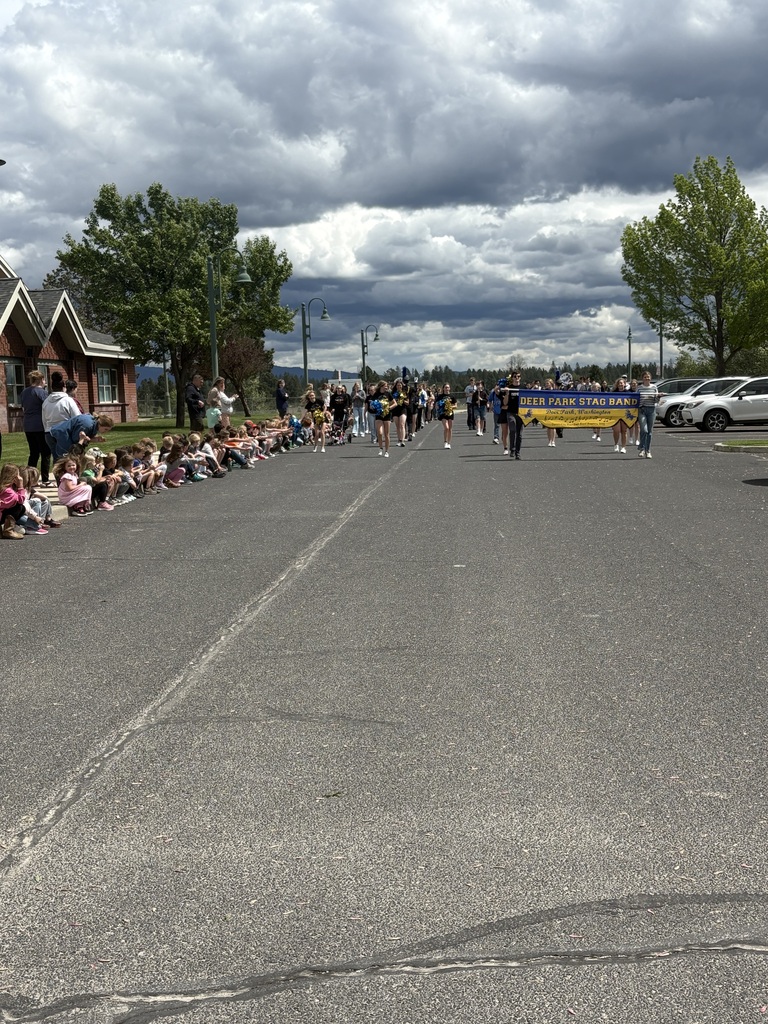 Elementary school students cheering on high school band