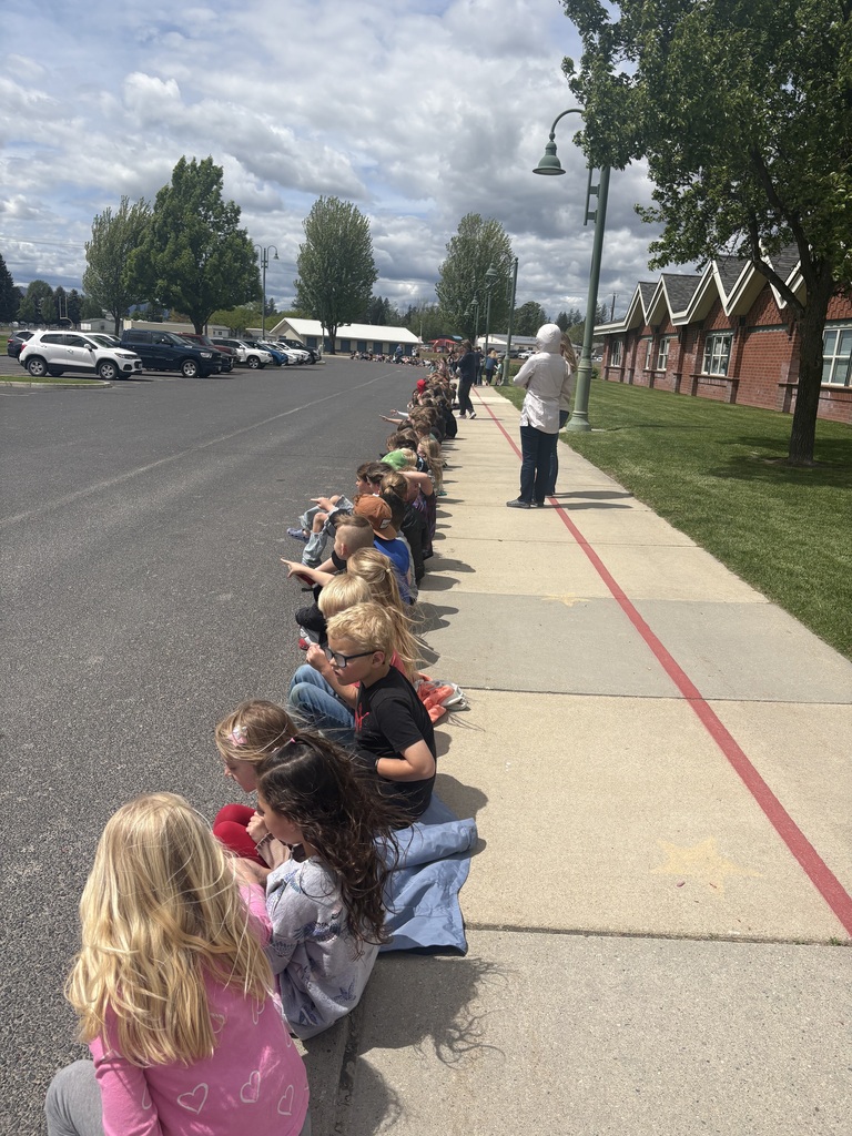 Elementary school students cheering on high school band