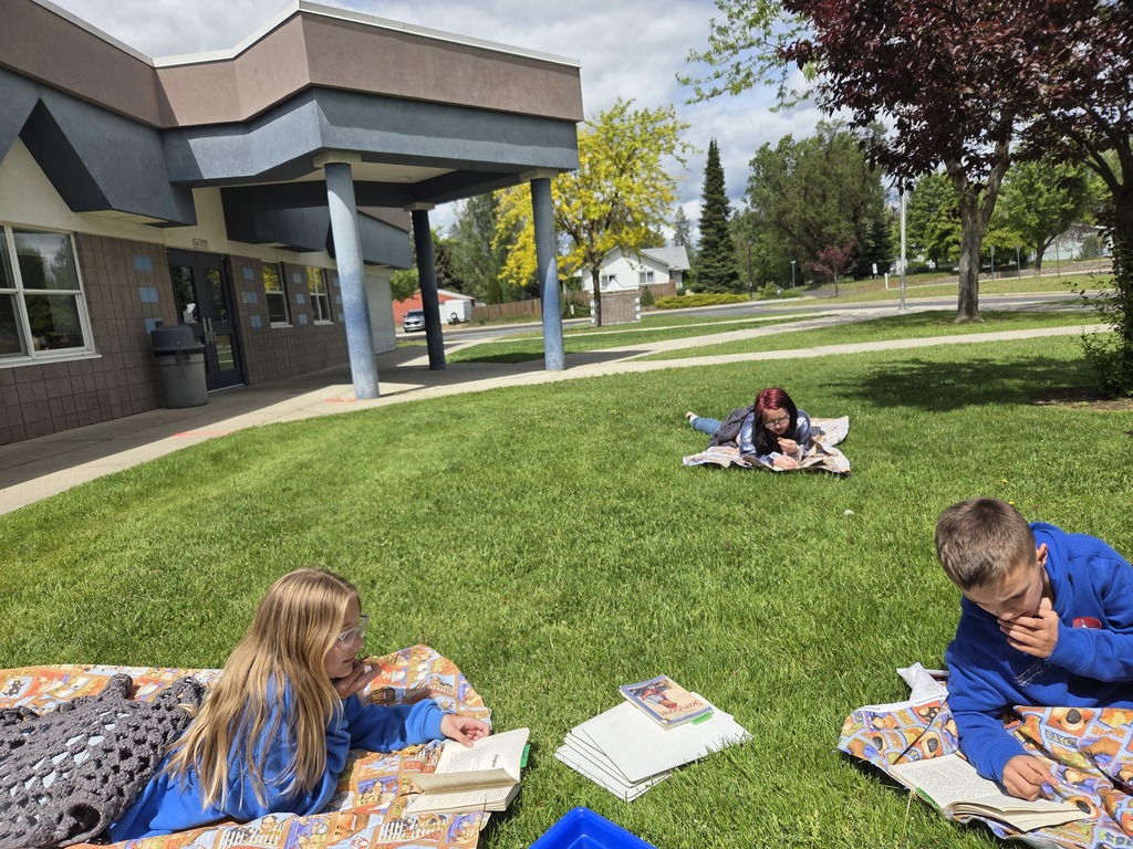 Students taking a testing break in the grass outside school.