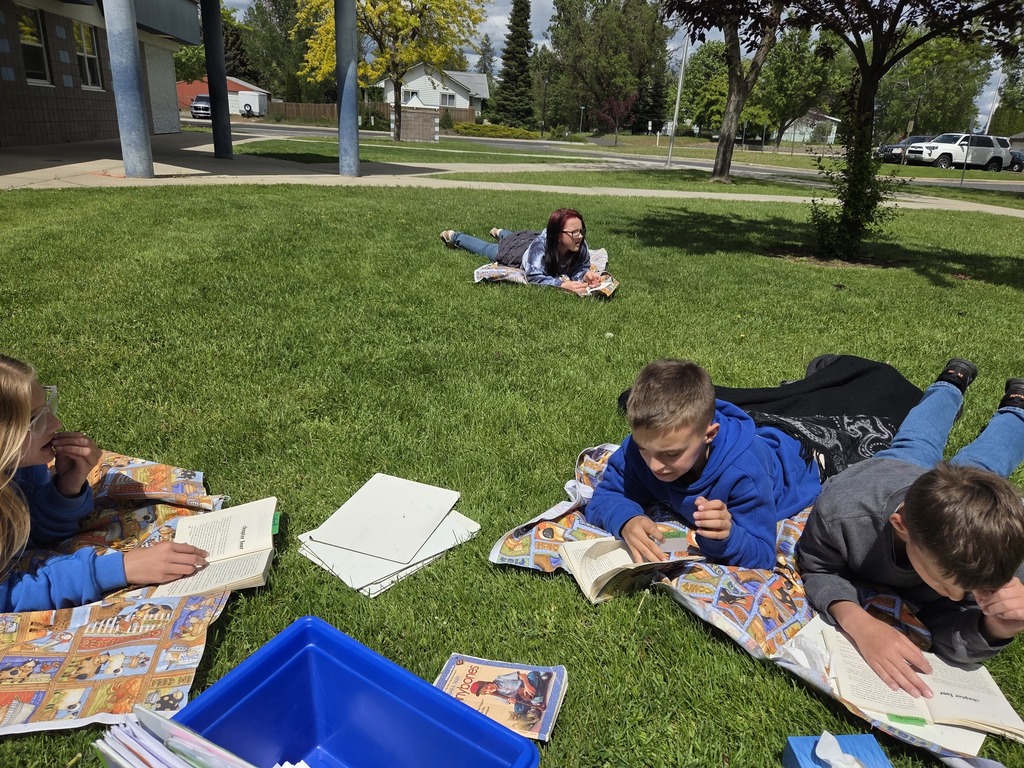 Students taking a testing break in the grass outside school.