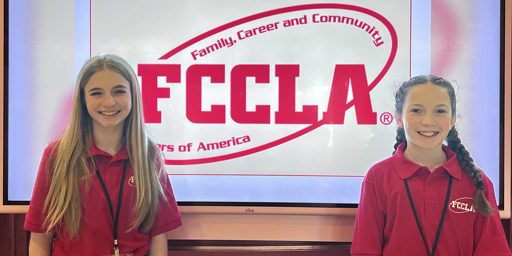 Addy Schultz and Olivia McGonigal in front of FCCLA sign