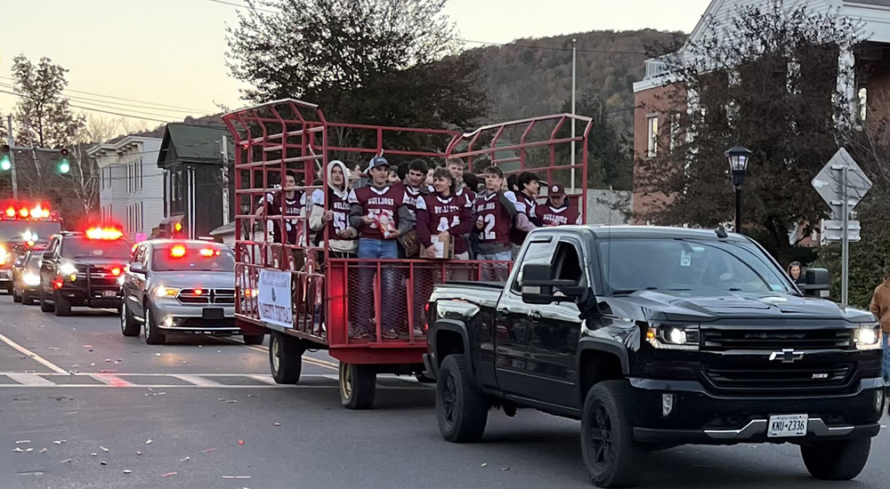 truck pulling hay wagon with football players in parade