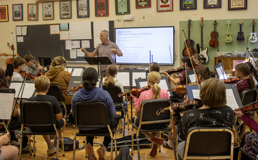 Mr. Baxter conducting the middle school orchestra