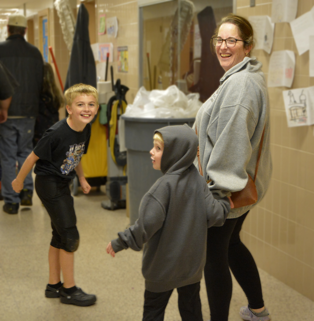 adult and two children laughing in hallway