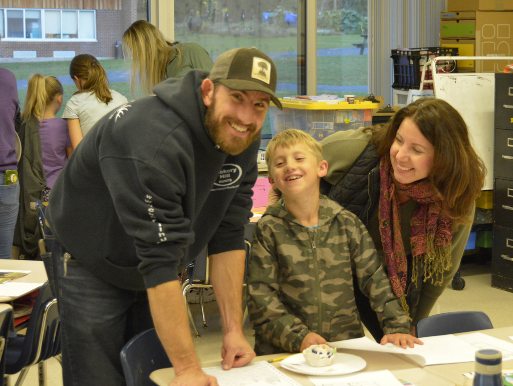 2 smiling adults and smiling child