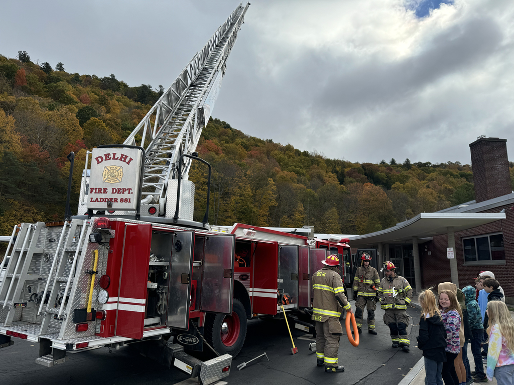 firefighters with fire truck speak to children i