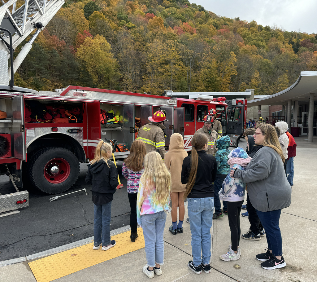 firefighters with fire truck speak to children i