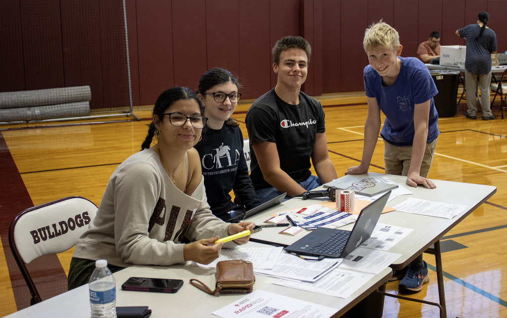 4 students smiling at table