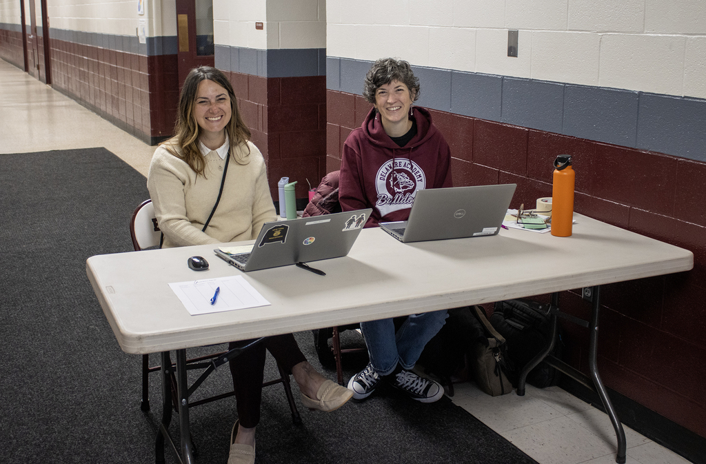 two women smiling at table
