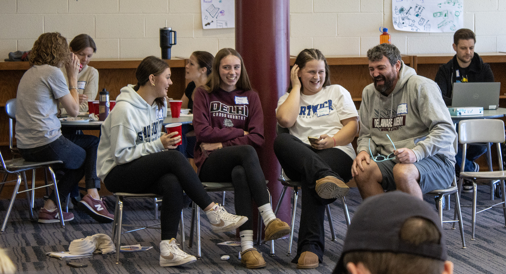 3 students and a teacher laughing