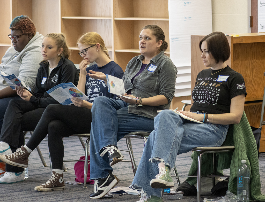 2 facilitators speak while 3 students listen