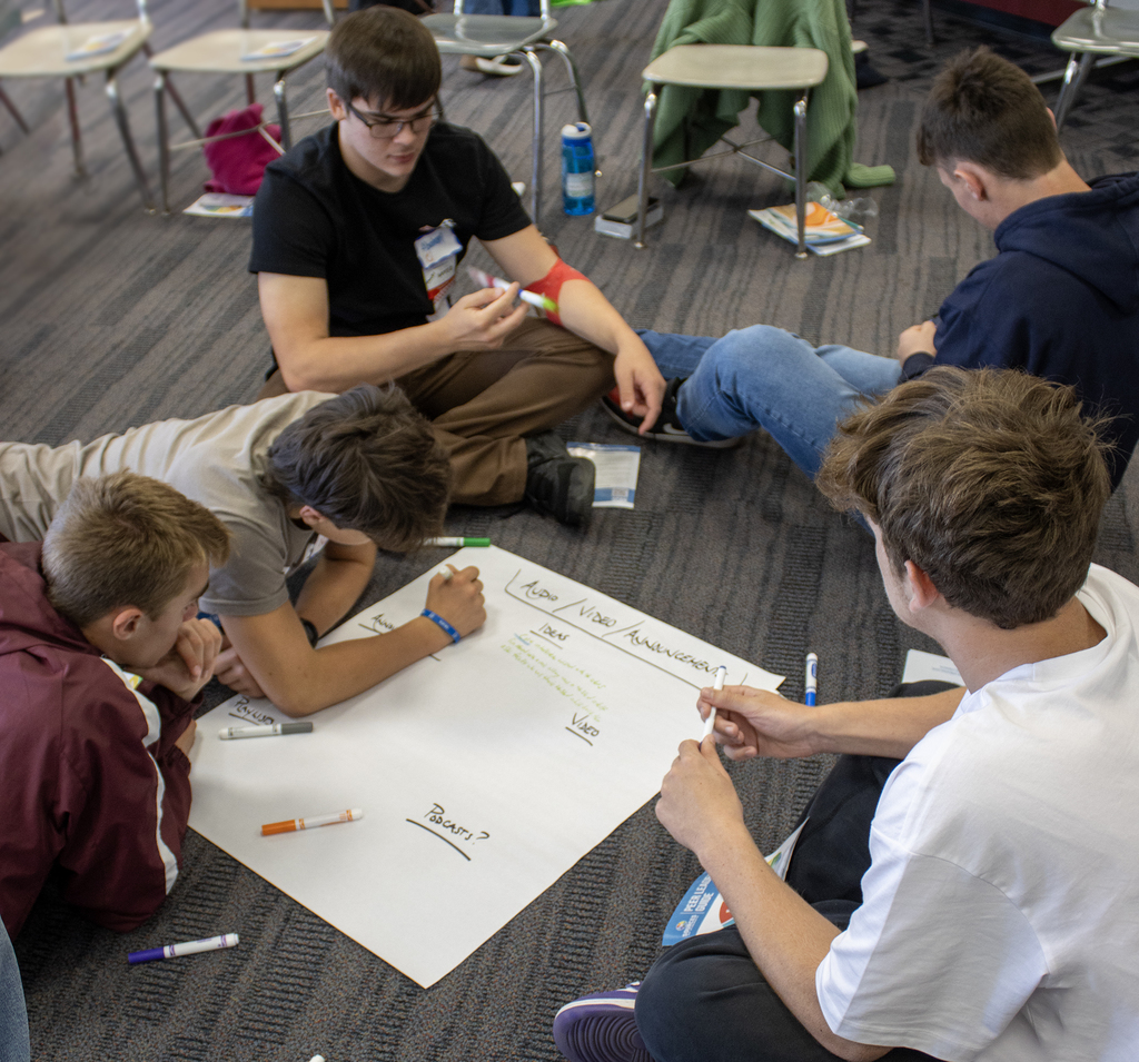 a group of students capture idea on a marker pad