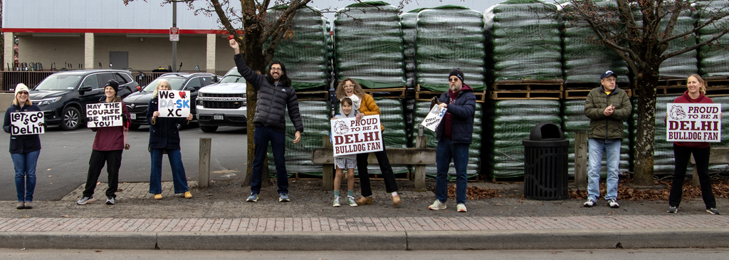 parents hold signs and cheer