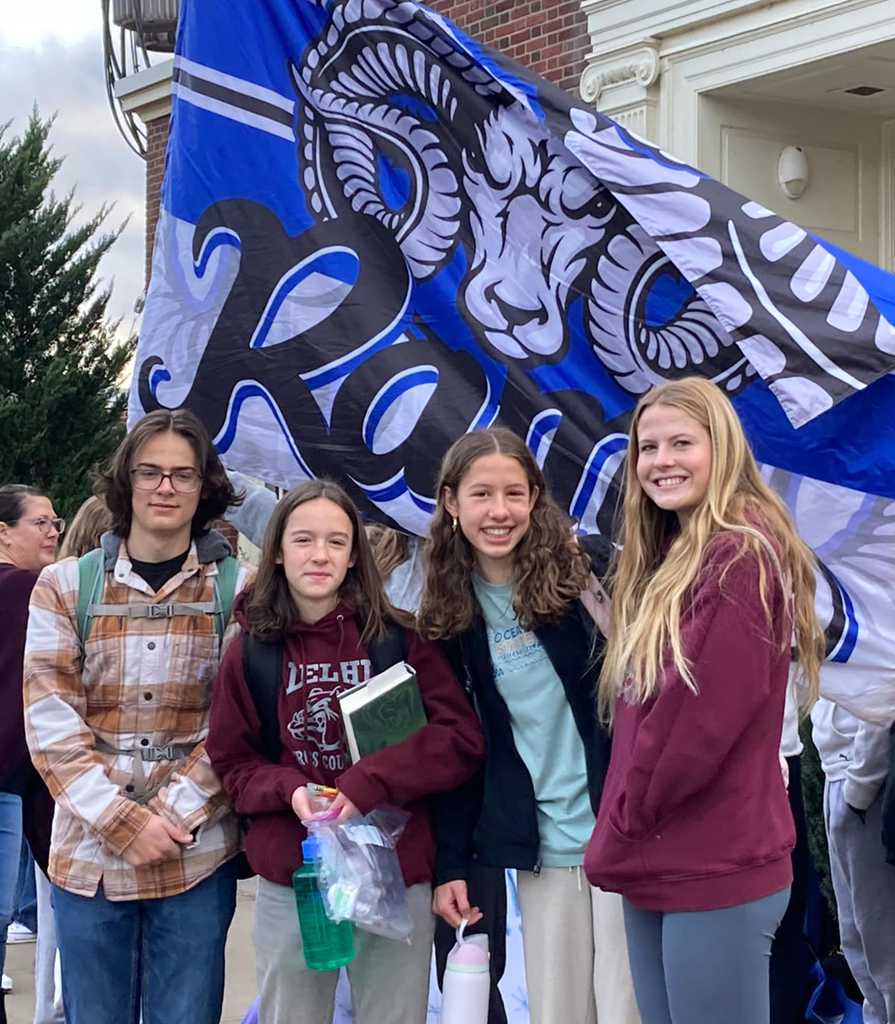 4 students in front of SK flag
