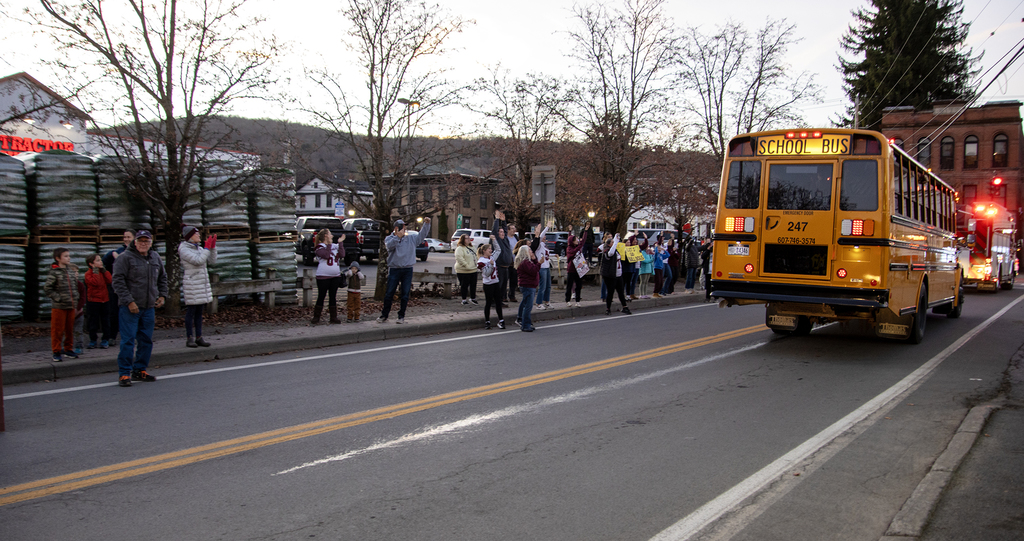 people cheer the school bus