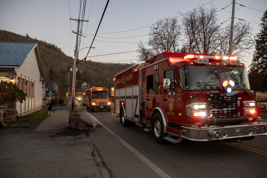 people cheer the fire truck and school bus