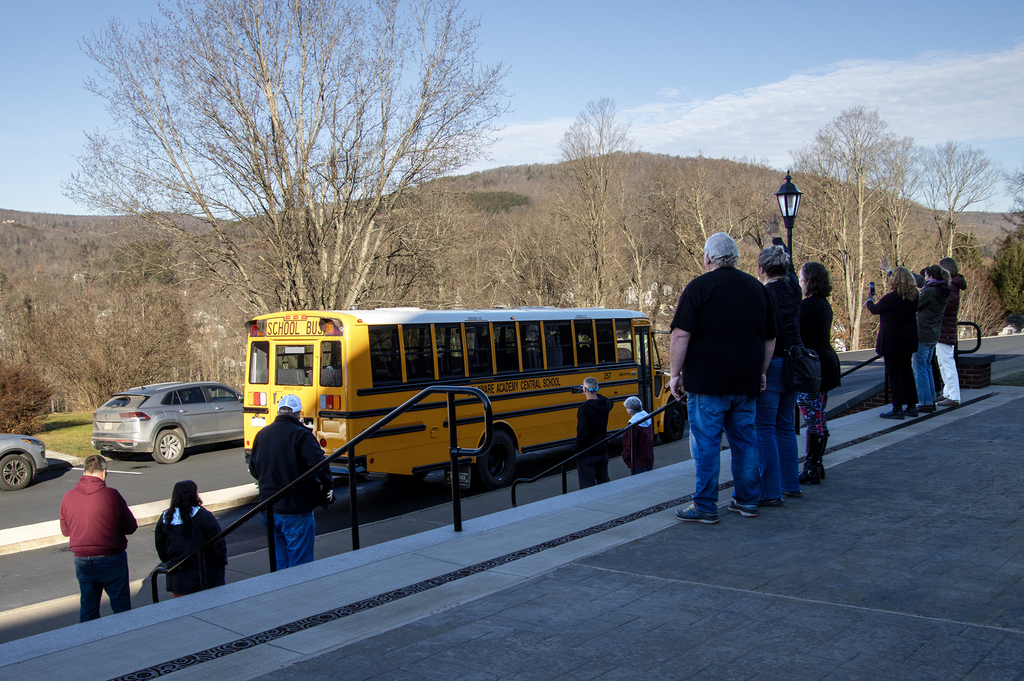parents wave goodbye to studeents on bus