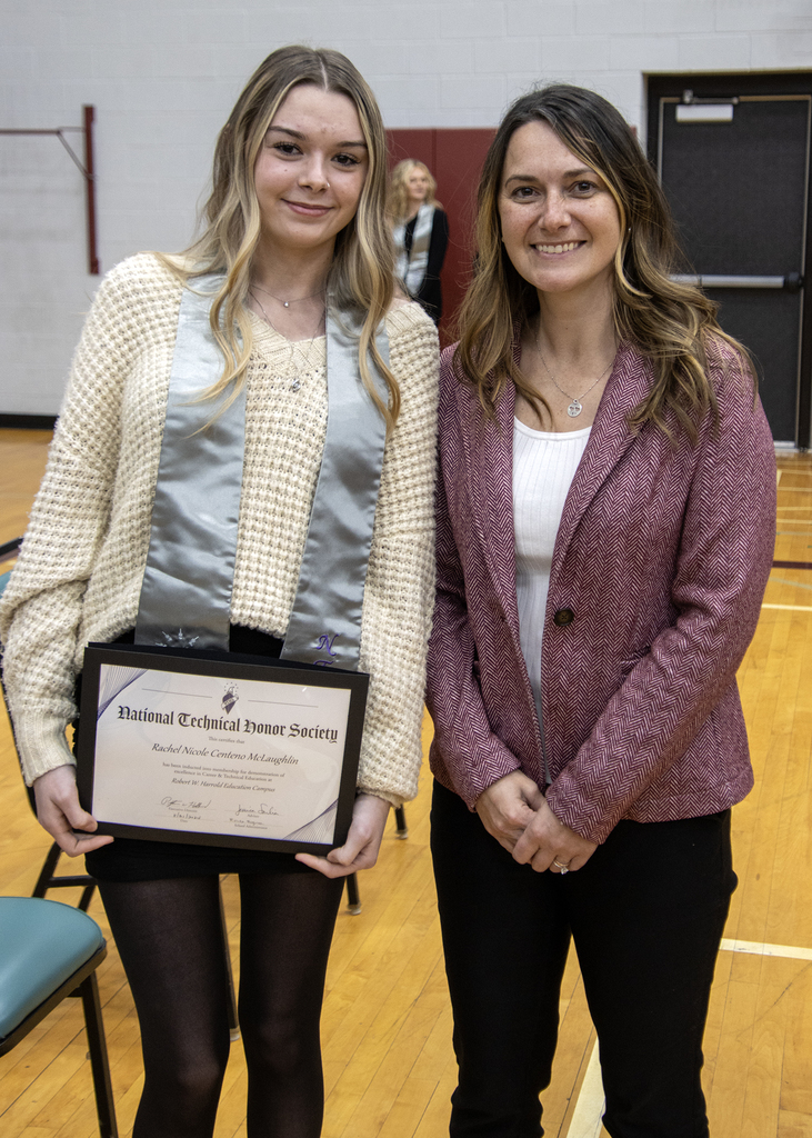 student poses with certificate and high school principal