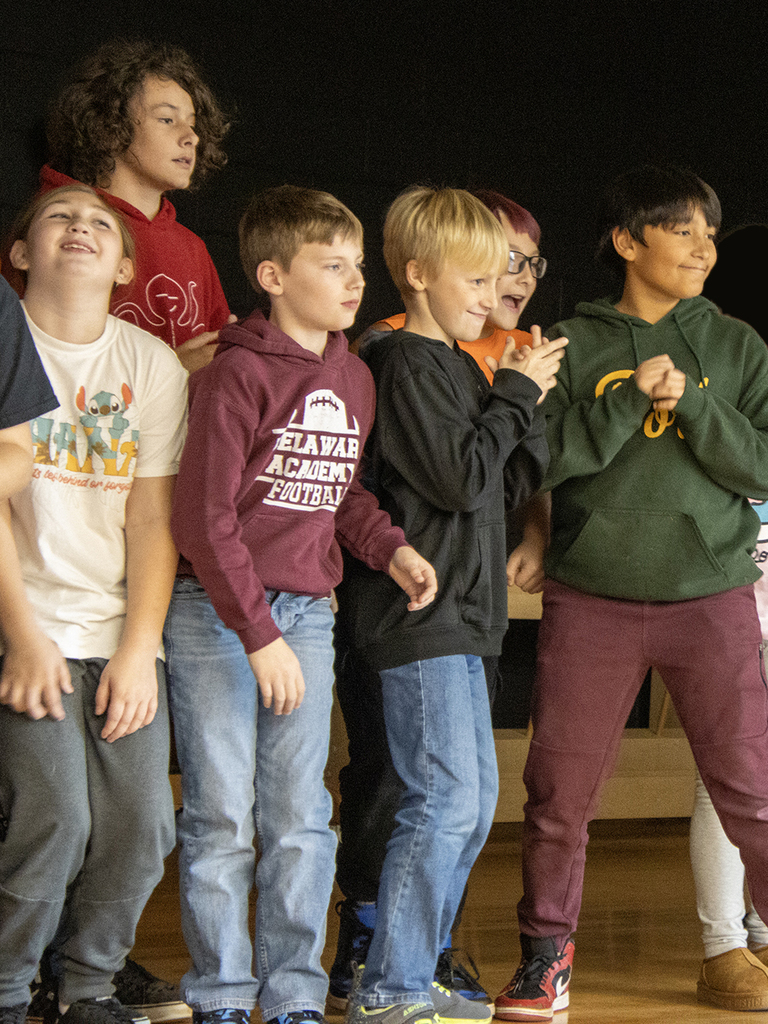 elementary stueents make expressions on stage