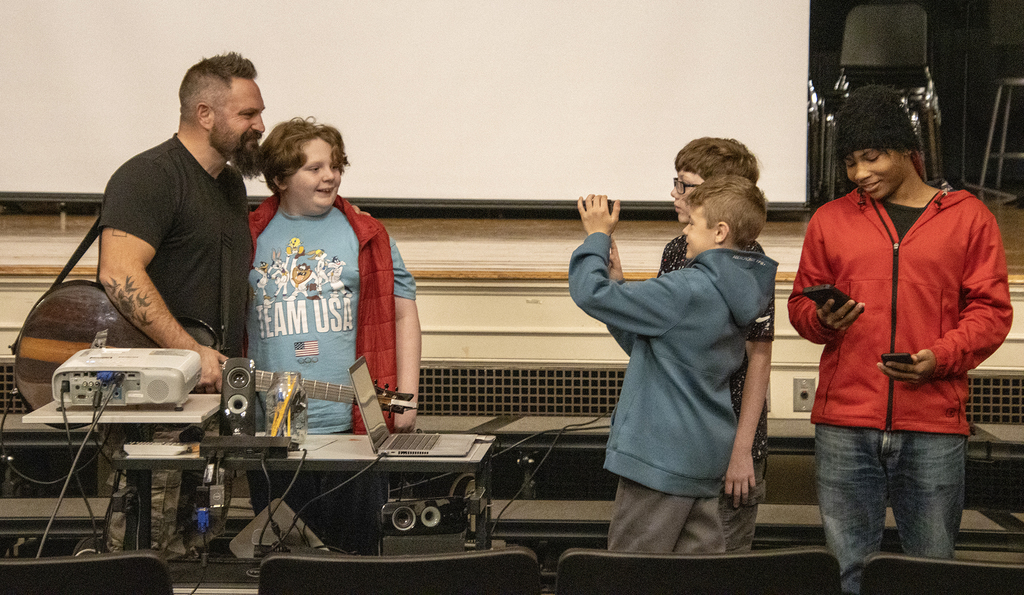 singer poses for selfies with students