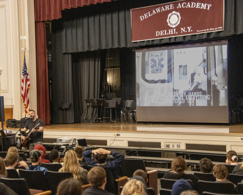 adult performs with a slide show on screen