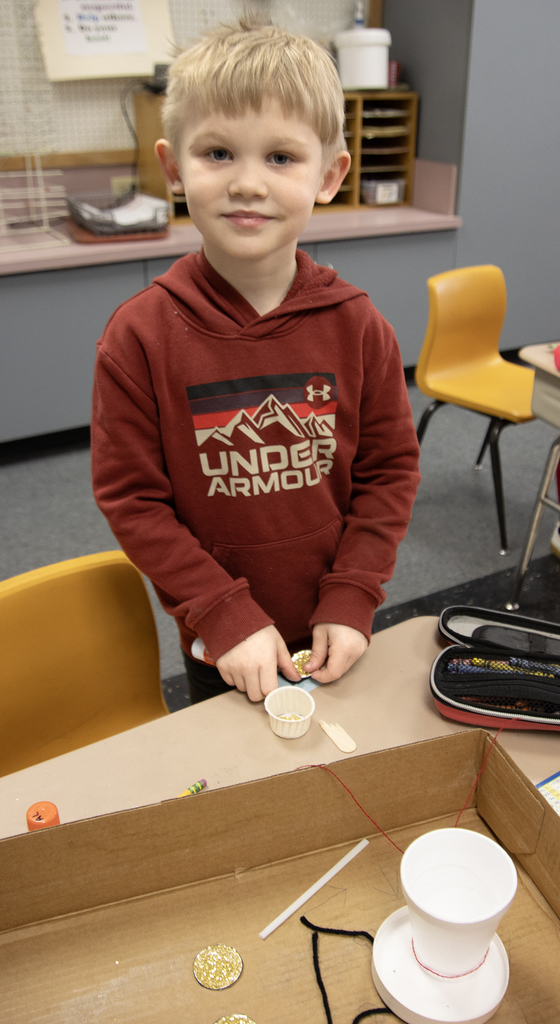 student poses with a leprechaun trap