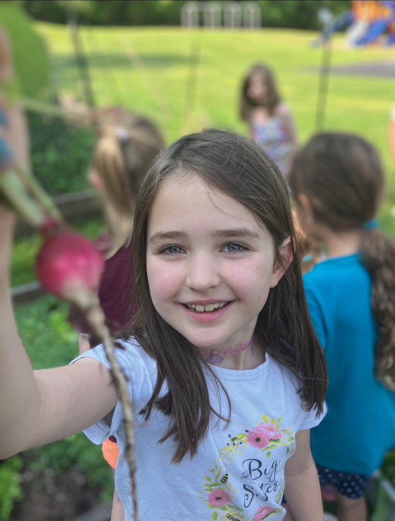 student holding radish she harvested